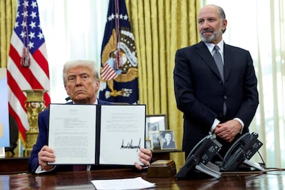 El presidente de Estados Unidos, Donald Trump, muestra un decreto sobre el aumento de aranceles, junto al secretario de Comercio, Howard Lutnick, el 13 de febrero en el Despaho Oval.