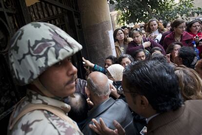 Un soldado vigila la entrada a un colegio electoral, con una masiva presencia de ciudadanos.