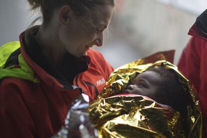 La voluntaria española, Laura Rasero, sostiene en sus brazos a Oulai Esther, de dos años, procedente de Costa de Marfil y rescatado por la ONG Proactiva Open Arms a 21 millas náuticas de la costa Libia, en el mar Mediterráneo.