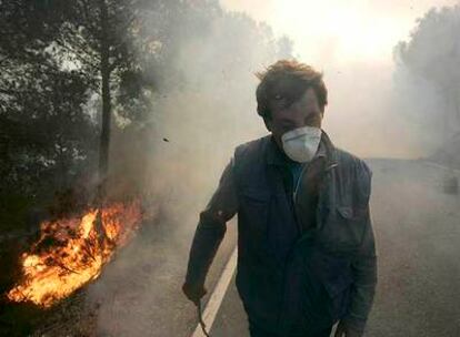 Un vecino escapa del humo y las llamas en uno de los incendios forestales que el viento propagó en Castellón.