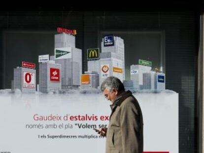 Un hombre pasa frente a una sucursal bancaria.