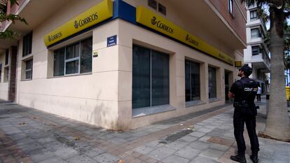 Un agente de la Policía Nacional hace guardia frente a la puerta de las Oficinas de Correos en Melilla, este jueves.