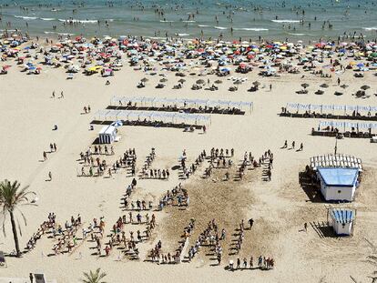 Una cadena humana sobre la arena en defensa del marjal de Gandia