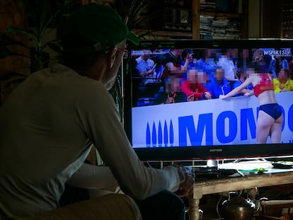 Un hombre mira contenidos de deporte femenino en YouTube en una televisión inteligente.