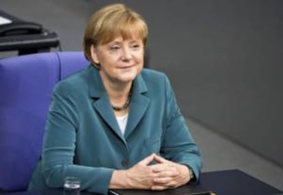 La canciller alemana, Angela Merkel (c), sonríe durante una sesión especial celebrada en el Bundestag, la Cámara Baja del Parlamento, para tratar las recientes inundaciones que afectaron al país, en Berlín (Alemania), hoy, martes 25 de junio de 2013.