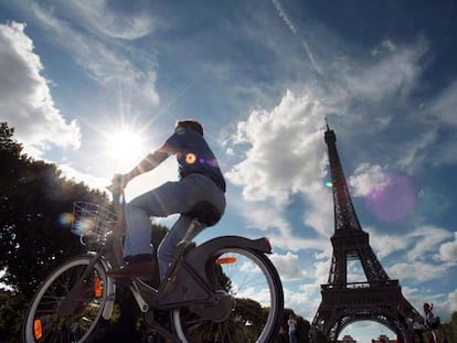 Un cicloturista pedalea por los alrededores de la torre Eiffel.