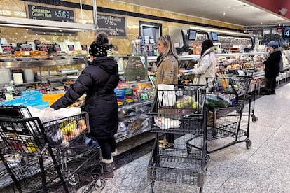 Customers wait for orders at a grocery store in Wheeling, Ill., Friday, Jan. 19, 2024