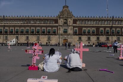 Dos mujeres protestan frente al Palacio Nacional de México.