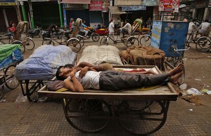 Trabajadores indios sobre un carro de carga en Allahabad, India. 18 de junio de 2014.