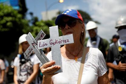 Una mujer sostiene dos cruces con los nombres de las víctimas de las últimas manifestaciones.