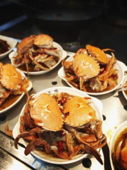 Platos de 'chili crab' en un puesto de comida callejera en Singapur.