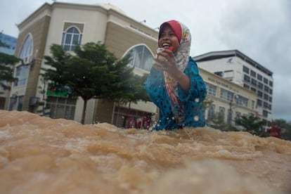 Una niña camina por una calle inundada de Kota Bahru (Malasia) tras las fuertes lluvias que azotaron el país.
