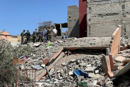 Personal de rescate trabaja sobre una montaña de escombros de un edificio colapsado en la población de Amizmiz. 