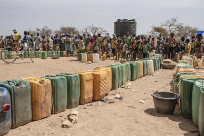 Fila de garrafas junto al depósito de agua en el Instituto Departamental de Barsalogho, hoy improvisado campo de refugiados del conflicto que vive Burkina Faso. El reparto suele estar limitado según la cantidad de miembros que tenga la familia.