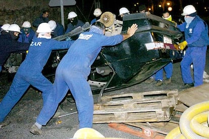 Varios trabajadores de La Naval de Sestao vuelcan un coche para montar una barricada incendiaria.