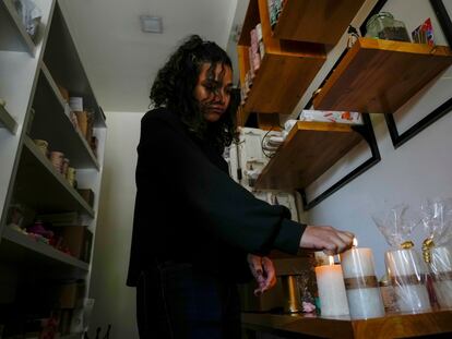 Una mujer enciende velas en su tienda después de un corte de energía programado ordenado por el Ministerio de Energía, en Quito, Ecuador.