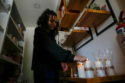 Una mujer enciende velas en su tienda después de un corte de energía programado ordenado por el Ministerio de Energía, en Quito, Ecuador.