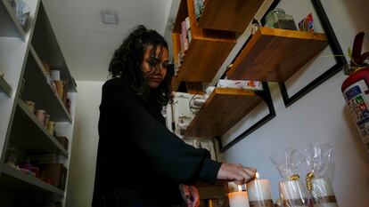Una mujer enciende velas en su tienda después de un corte de energía programado ordenado por el Ministerio de Energía, en Quito, Ecuador.
