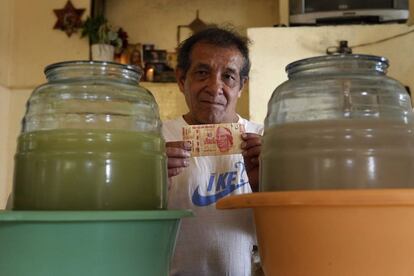 Jorge, de 60 años, con en sus manos 100 pesos mexicanos en el bar "La antigua Roma", en el DF (México). Jorge padece una sordera muy avanzada, y trabaja como camarero 11 horas al día desde hace 30 años.