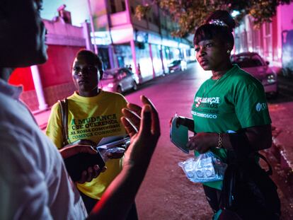 Armados con listas de mujeres para contactar, dos trabajadoras comunitarias hablan con personas en el distrito de luz roja del puerto de Maputo, Mozambique, para brindar información sobre prevención y derivación del VIH a quienes la necesitan.