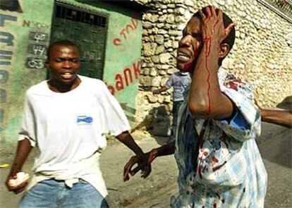 Un estudiante busca ayuda tras resultar herido por seguidores de Aristide en Puerto Príncipe.