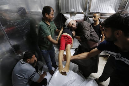 El cuerpo de una niña palestina, que murió en los ataques isralíes, es trasladada a la morgue del hospital Al-Shifa de Gaza, este lunes.