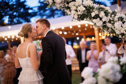 Una pareja se besa durante la celebración de su boda.