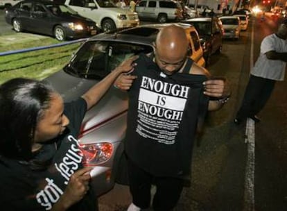 Dos manifestantes llegados ayer a Jena preparan una camiseta en la que se lee "¡Basta ya!".