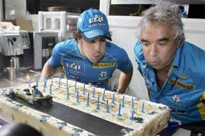 Fernando Alonso sopla las velas de la tarta de su 25 cumpleaños junto al director Renault, Flavio Briattore.