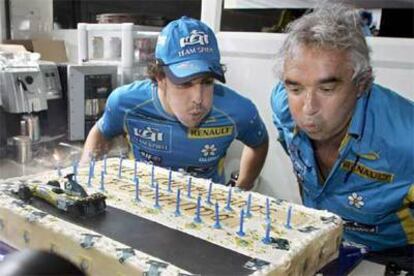 Fernando Alonso  sopla las velas de la tarta de su 25 cumpleaños junto al director Renault, Flavio Briattore.