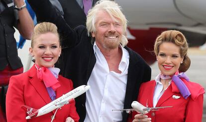 Richard Branson con dos azafatas de Virgin. 