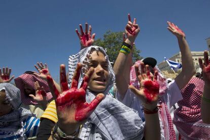 Jóvenes israelíes con pañuelo palestino y las manos teñidas de rojo.