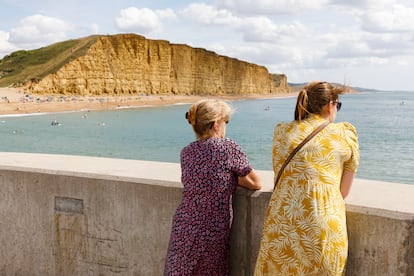 Dos mujeres miran al mar de Dorset, Inglaterra, el Agosto de 2022