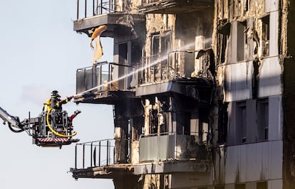 Bomberos trabajan en uno de los edificios afectados por el incendio.