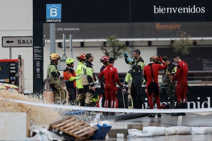 Bomberos y policías en el parking de Bonaire en Aldaia, Valencia, este lunes.