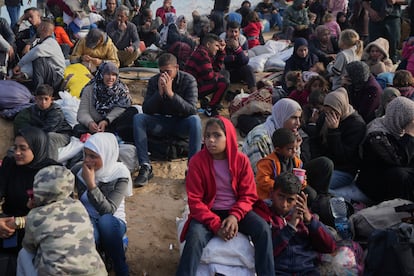 Palestinos esperan en el centro de Gaza a poder cruzar al norte, este domingo.