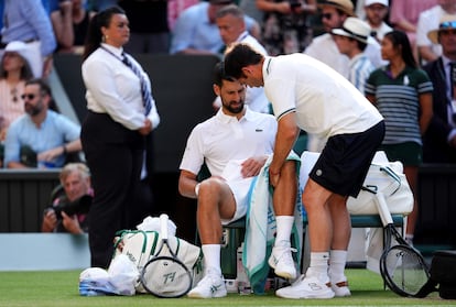 Djokovic es atendido por el fisio del muslo.