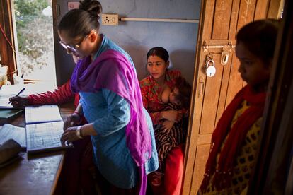 Una mujer da el pecho a su bebé mientras espera su turno en el centro de salud de Devabhumi Baluwa, en el distrito de Kavre, en Nepal. Esta zona se vio muy afectada por los terremotos de 2015, tanto es así que el puesto sanitario quedó gravemente dañado. Con miedo, el personal sigue pasando consulta allí hasta que se inaugure el nuevo.