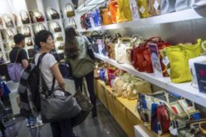 Una mujer observa una colecci&oacute;n de bolsos en las Galer&iacute;as Lafayette en Par&iacute;s (Francia).