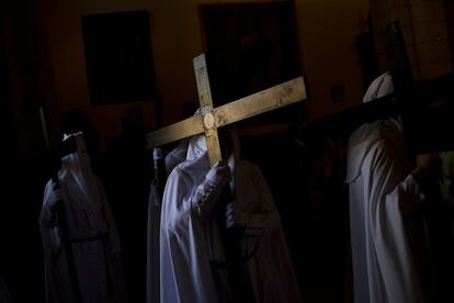 Miembros de la hermandad de La Paz esperan dentro de la iglesia para participar en una procesión en Sevilla.