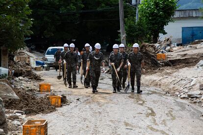 Soldados surcoreanos llegan para limpiar los escombros generados por las fuertes lluvias en Cheongju, este el lunes 17 de julio. 
