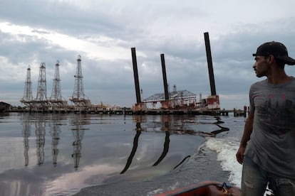 Un pescador navega junto a la infraestructura en ruinas de una plataforma de PDVSA, en el lago Maracaibo en mayo de 2019.