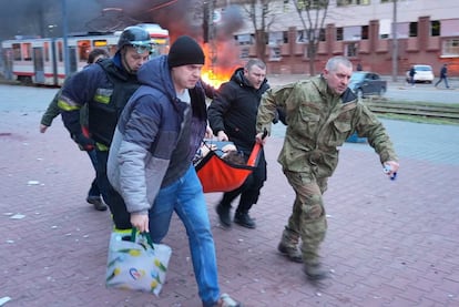 Personal de emergencias y vecinos de la zona trasladaban este miércoles a un herido del ataque ruso en Zaporiyia.