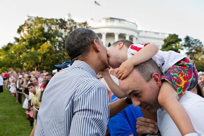 Un niño se acerca a dar un beso al presidente durante un encuentro con familias de congresistas en la Casa Blanca.