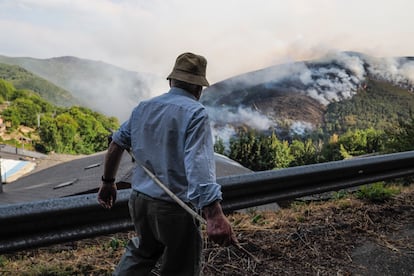 Un vecino de la aldea de Vicuña (Lugo) contempla el incendio originado en Larouco (Ourense).
