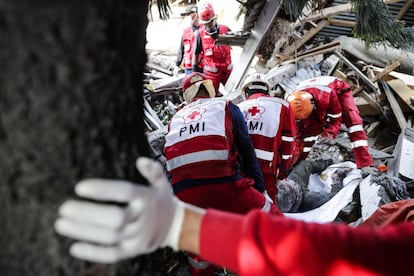 Miembros de la Cruz Roja recuperan el cuerpo sin vida de una de las víctimas del tsunami en la playa de Talise, en Palu.