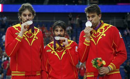 12 de agosto de 2012. Marc Gasol, Juan Carlos Navarro y Pau Gasol (de derecha a izquierda), besan en el podio la medalla de plata conseguida después de que España resultara derrotada por Estados Unidos por 107-100, en la final de la competición de baloncesto de los Juegos Olímpicos de Londres 2012