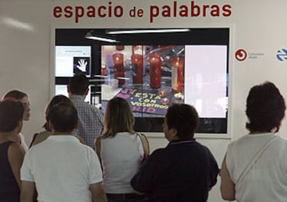 Varias personas dejan sus mensajes en el espacio habilitado en la estación de Atocha.