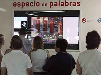 Varias personas dejan sus mensajes en el espacio habilitado en la estación de Atocha.