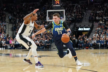 Luka Doncic,  jugador de Dallas Mavericks, trata de driblar a DeMar DeRozan, de San Antonio Spurs.